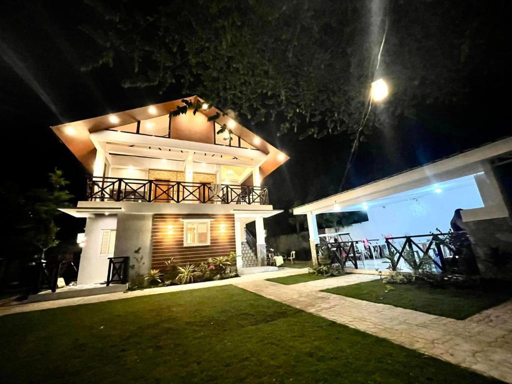 a house at night with a lawn in front of it at The farmhouse villa beach resort in Morong