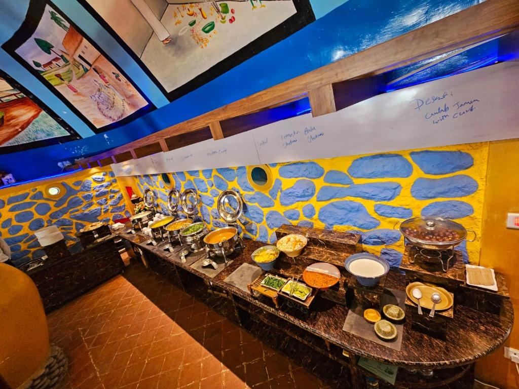 una linea a buffet con molti tipi di cibo diversi di Afno Ghar Temple Resort a Dhangarhi