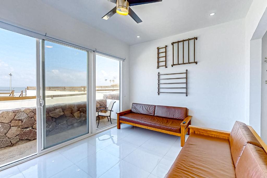 sala de estar con sofá y ventana grande en Casa Fresno 23 - Playa Arcangel en Rosarito