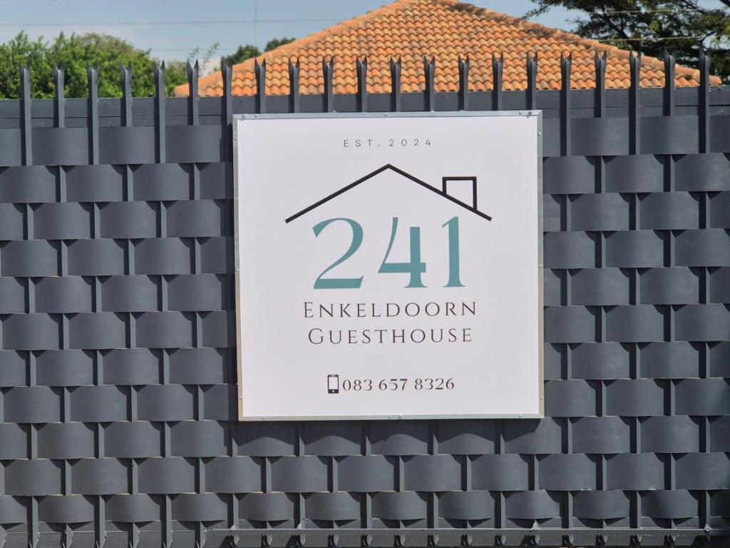 a sign for a house on a fence at @241 Enkeldoorn Guesthouse in Pretoria