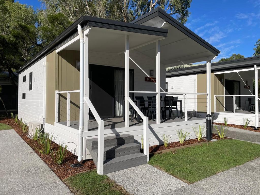 a white cottage with a black roof at BIG4 Tweed Billabong Holiday Park in Tweed Heads