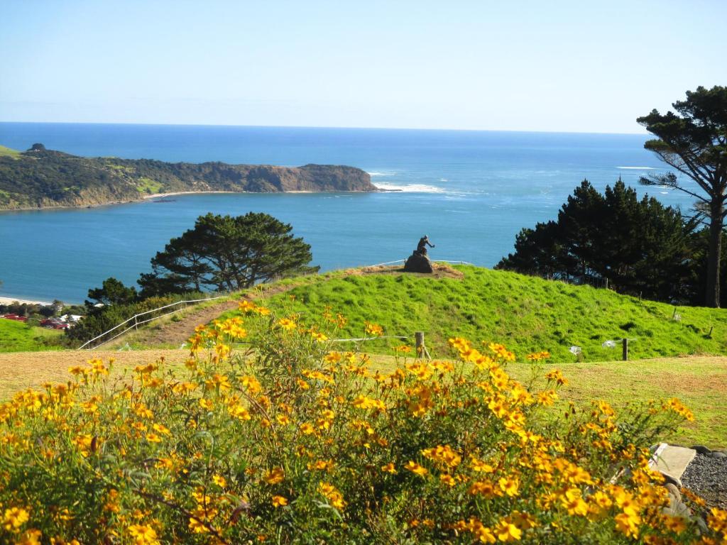 een geit op een heuvel met uitzicht op de oceaan bij The Healthy Guesthouse 