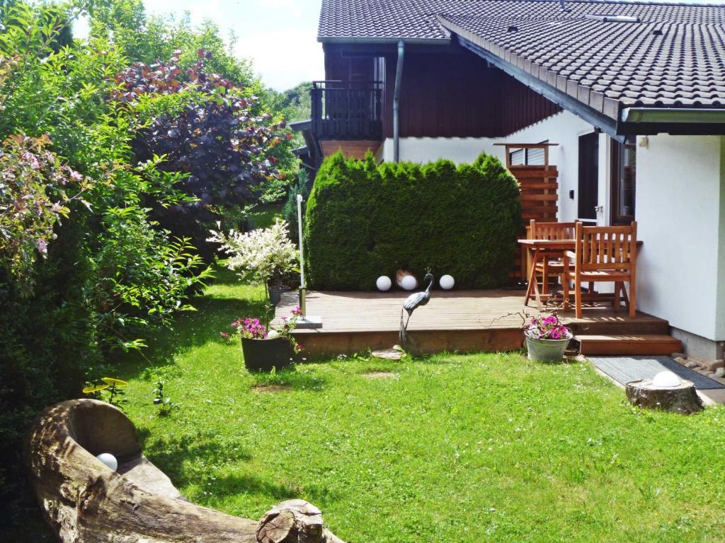 AnraffにあるFerienwohnung Bergblickの木製デッキ(テーブル、椅子付)が備わる裏庭