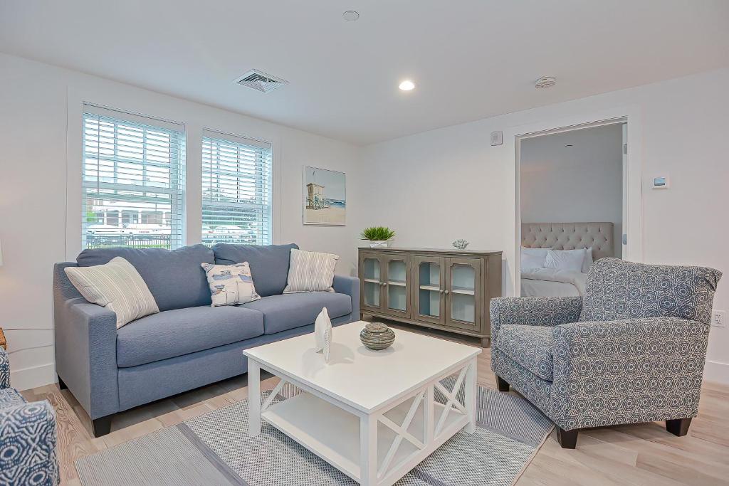 a living room with a blue couch and two chairs at Harbourtown Suites, Unit 213 in Plymouth