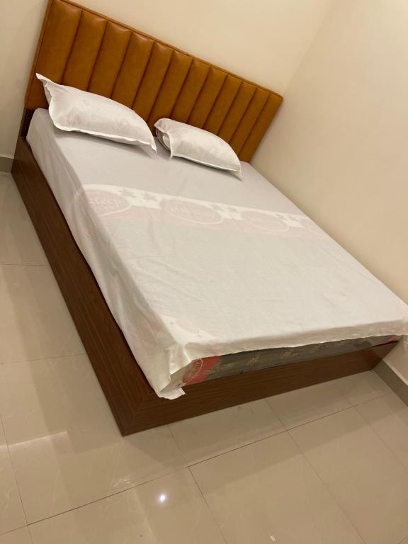 a bed with white sheets and pillows on it at KM MANSION in Chennai