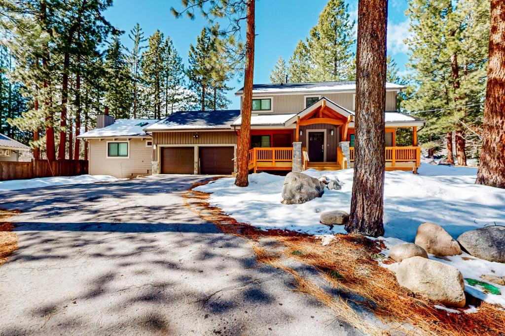 una casa en el bosque con nieve y árboles en Piney Way, en Incline Village