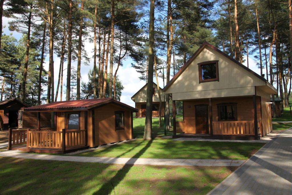 a small cabin in the grass next to trees at Blue Resort Ostrowo in Ostrowo