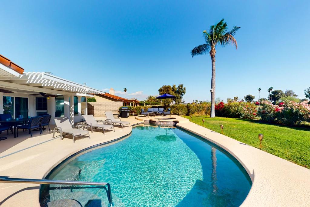 パームデザートにあるPalm Desert Doveのヤシの木が植えられた裏庭のスイミングプール