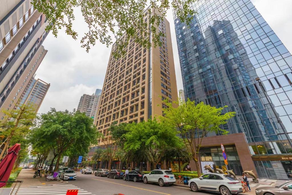 una calle de la ciudad con coches aparcados frente a edificios altos en Yidu-Doya Apartment, en Guangzhou