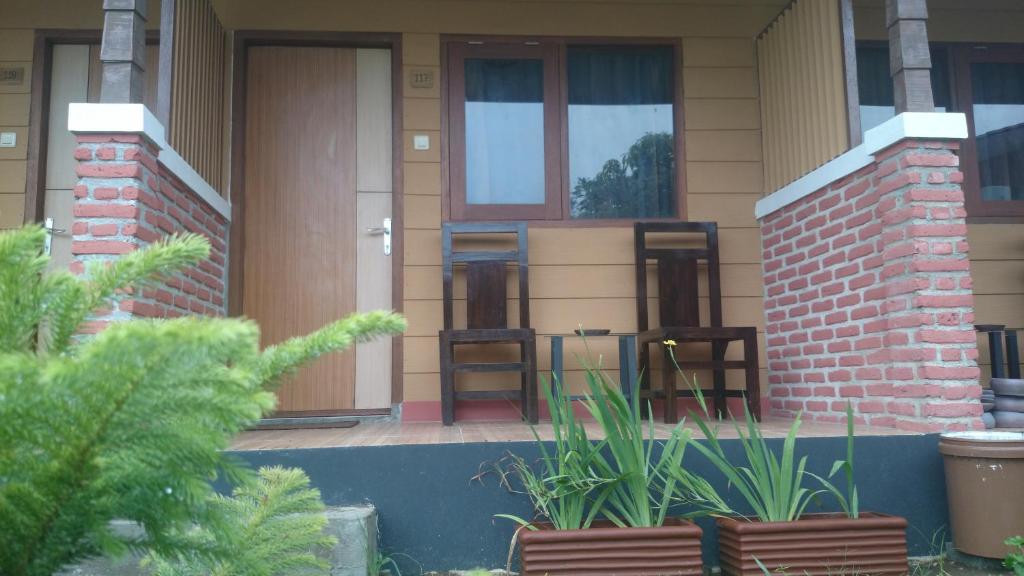 een huis met stoelen en planten ervoor bij Roemah kita hotel in Ngaglik