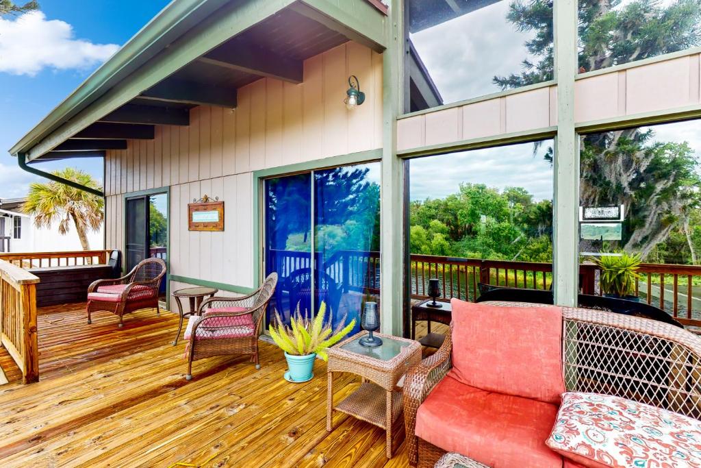 a porch with a red couch on a wooden deck at Riverside Serenity - Unit A in Bradenton