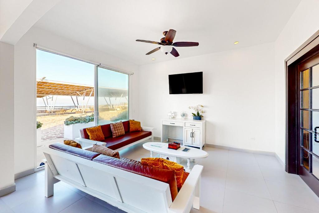 a living room with a couch and a ceiling fan at Villa Dorado 57 - Playa Arcangel in Rosarito