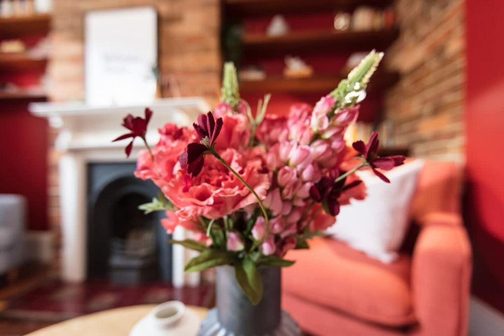 a vase of flowers on a table in a living room at Cute Heritage Home with Balcony close to the City in Sydney