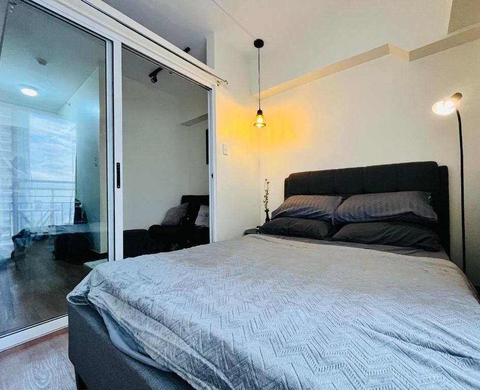 เตียงในห้องที่ Modern Contemporary 1BR Fully Furnished Condo with Balcony at Prisma Residences