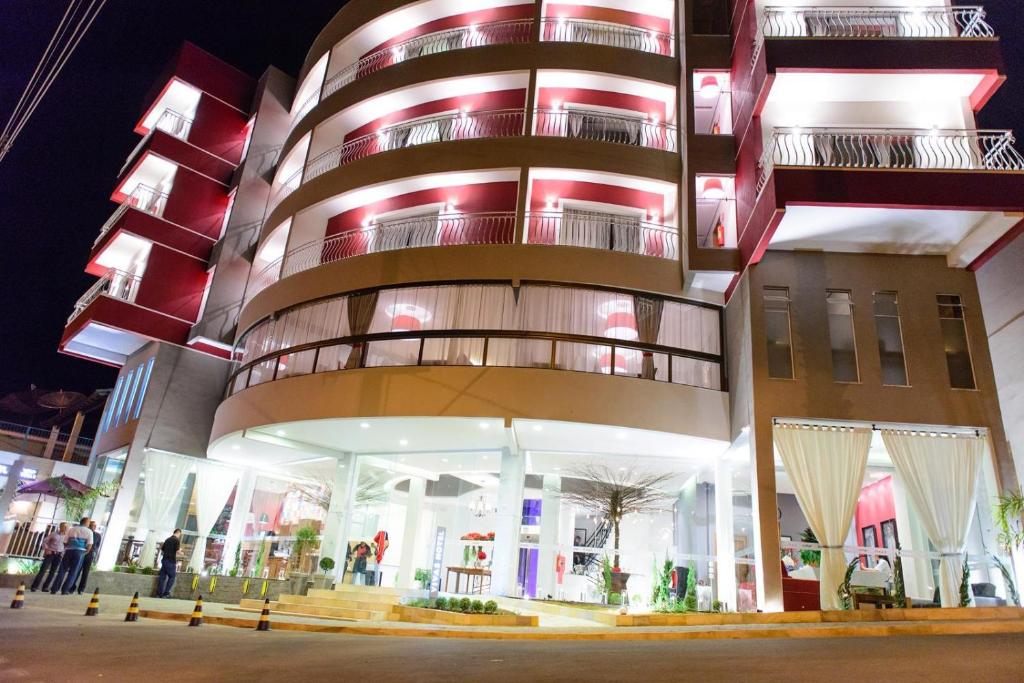 un gran edificio con una fachada circular por la noche en Vivas Hotel e Casa en Monte Sião