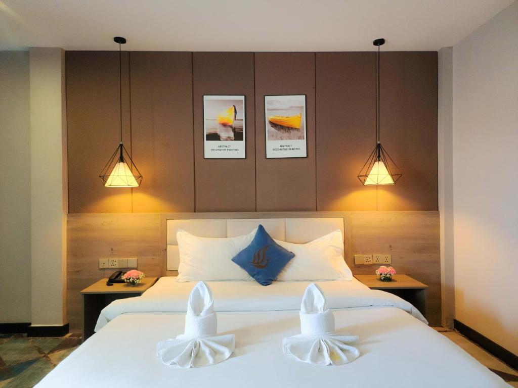 1 dormitorio con 1 cama con 2 almohadas blancas en Sunshine Hotel, en Phnom Penh