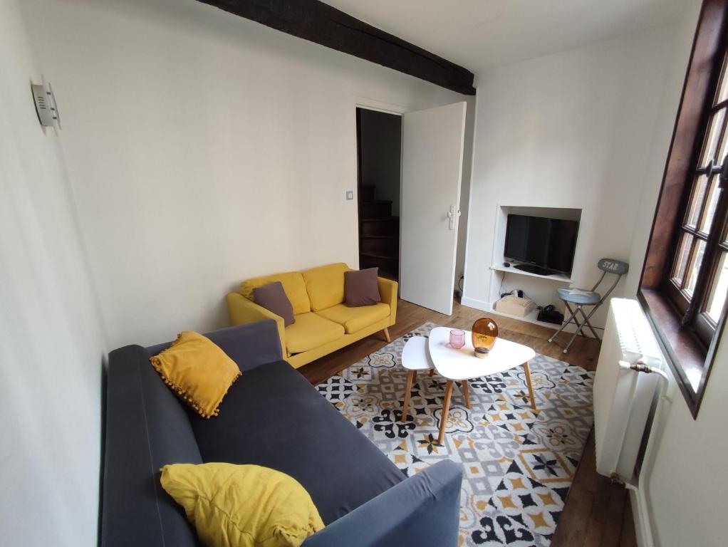 - un salon avec un canapé jaune et une table dans l'établissement Maison atypique à colombage Poitiers Centre, à Poitiers