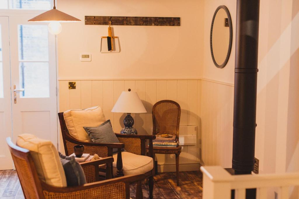 ein Wohnzimmer mit Korbstühlen und einem Tisch in der Unterkunft Buckingham Mews _ Rockpool Cottage 5 in Kent