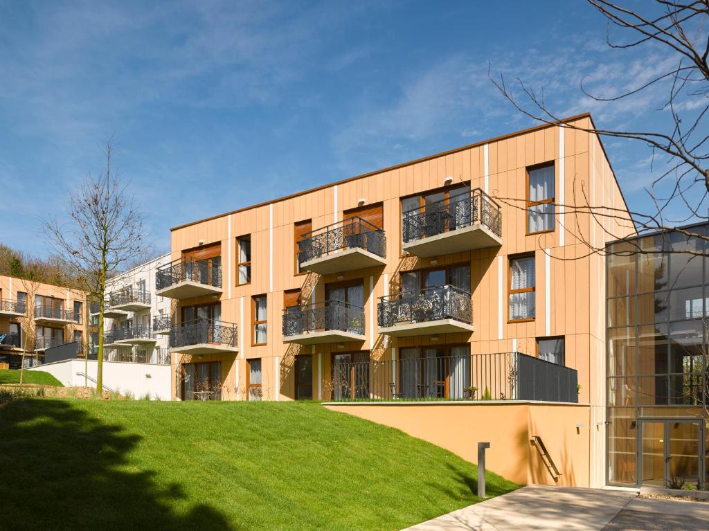 un immeuble d'appartements avec des balcons sur le côté dans l'établissement Résidence de Mons en Baroeul, à Mons-en-Baroeul