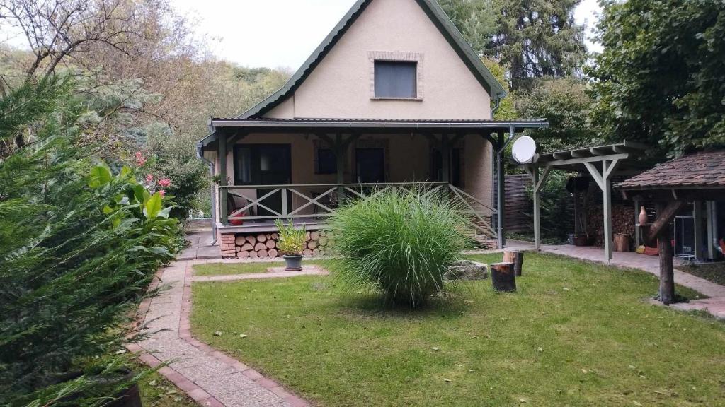 una casa con un patio de hierba delante de ella en Kispatak Erdei Ház, en Kismaros