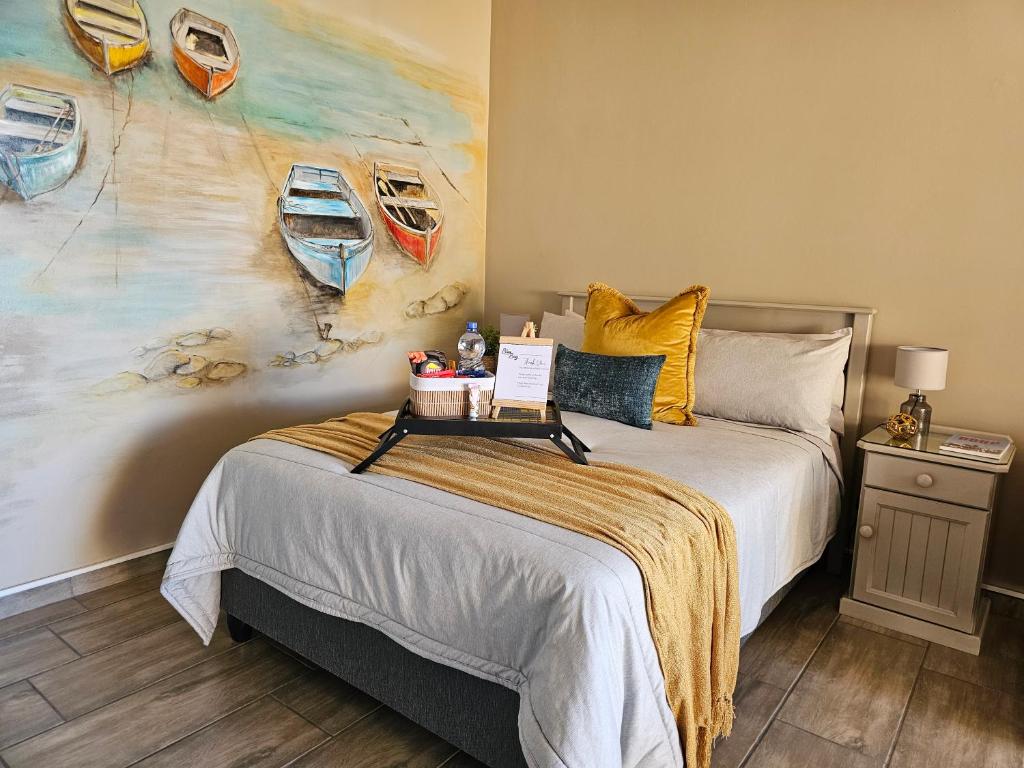 a bedroom with a bed and a painting of boats at Bliss on JBay - Blissful in Jeffreys Bay