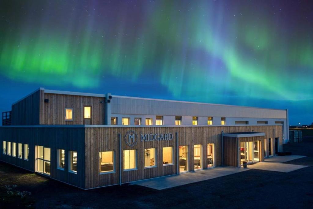 um edifício de escritórios com as luzes do norte no céu em Midgard Base Camp em Hvolsvöllur