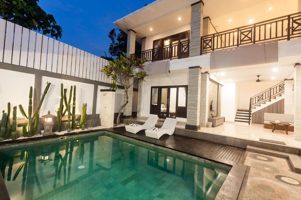 eine Villa mit Swimmingpool und ein Haus in der Unterkunft Maja Villa Batubelig by Pramana Villas in Canggu