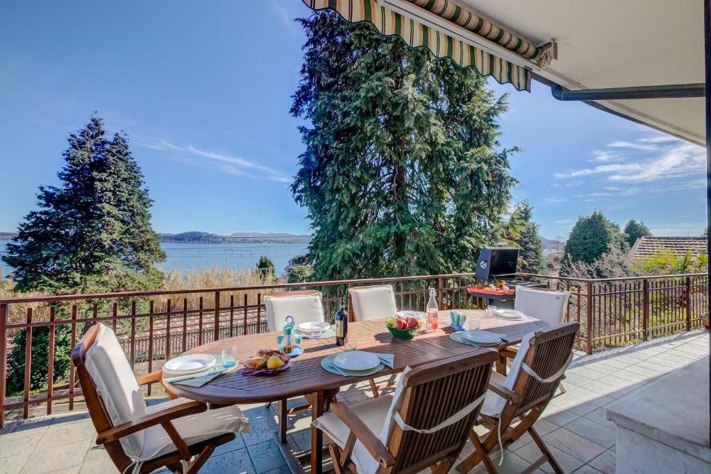 un tavolo e sedie in legno su un patio di Blooming Villa Cos Lake View - Happy Rentals a Belgirate