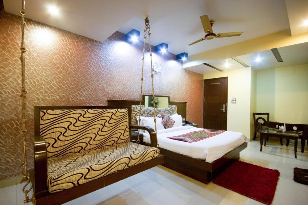 um quarto com uma cama de baloiço num quarto em Hotel Shivdev International em Nova Deli