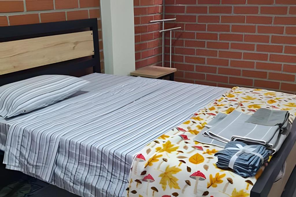 a bedroom with a bed with a blanket with a backpack at Apartaestudio 301 velódromo in Medellín