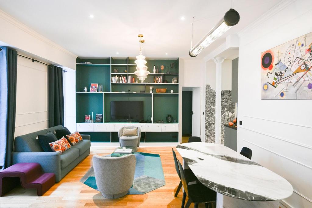 un salon avec un canapé et une table dans l'établissement Le Marais Pl de la Bastille 3BD 3BTH for 10 guests, à Paris