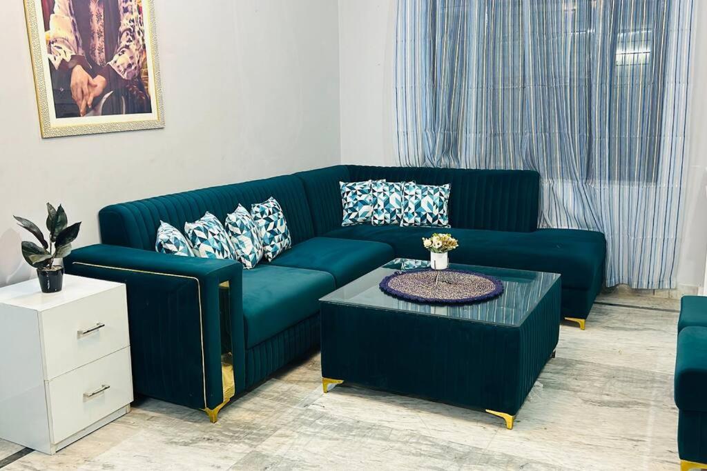 a living room with a blue couch and a table at work stay enjoy outdoor party in Faridabad