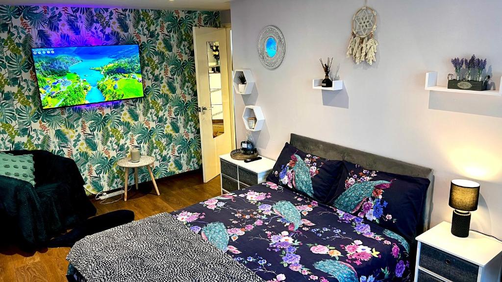 sypialnia z łóżkiem i telewizorem na ścianie w obiekcie Comfy apartment w Londynie