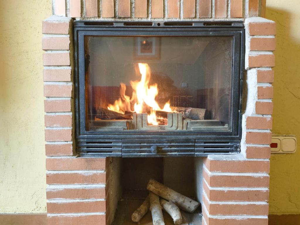 Una chimenea de ladrillo con fuego. en Alojamientos La Dehesa, en El Berrueco