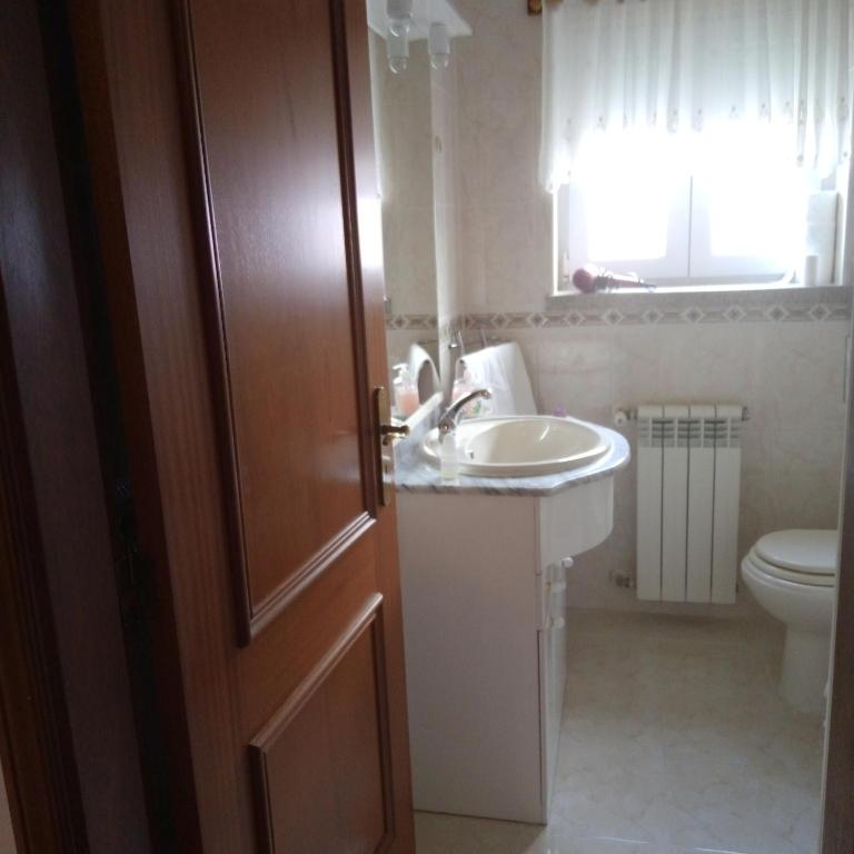 uma casa de banho com um lavatrio, um WC e uma porta em Terra Mista Alojamento Local em Gouveia