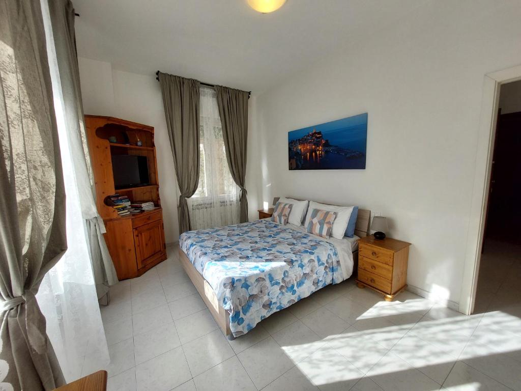 ein Schlafzimmer mit einem Bett und einem TV in der Unterkunft Casa Armilla in La Spezia