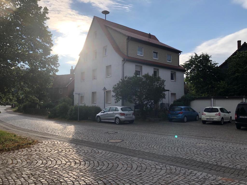 a white house with cars parked in front of it at Ferien- und Monteurwohnungen Andrej in Eisenach