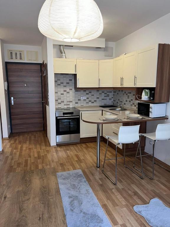 a kitchen with white cabinets and a table and chairs at Lux Cordia Apartment with free parking in Budapest