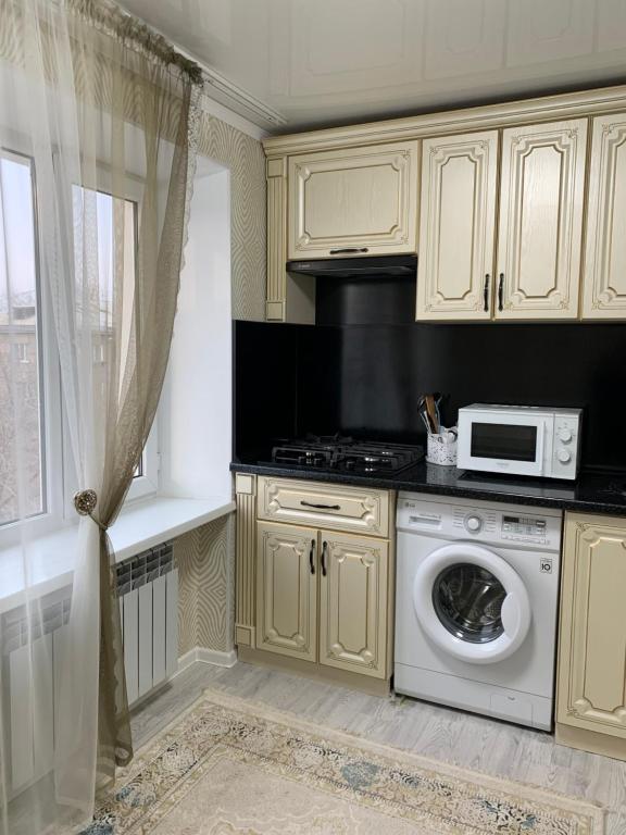 a kitchen with a white oven and a microwave at ИП.МЕДИНА in Taraz