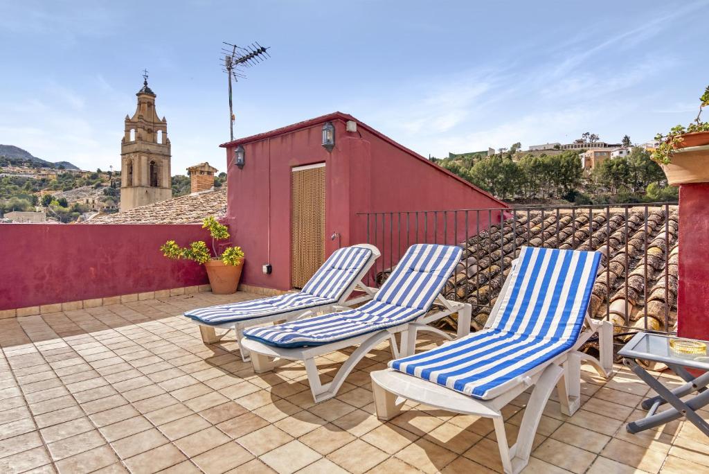 4 sillas en un patio con un edificio rojo en Ca Lluis, en Campell