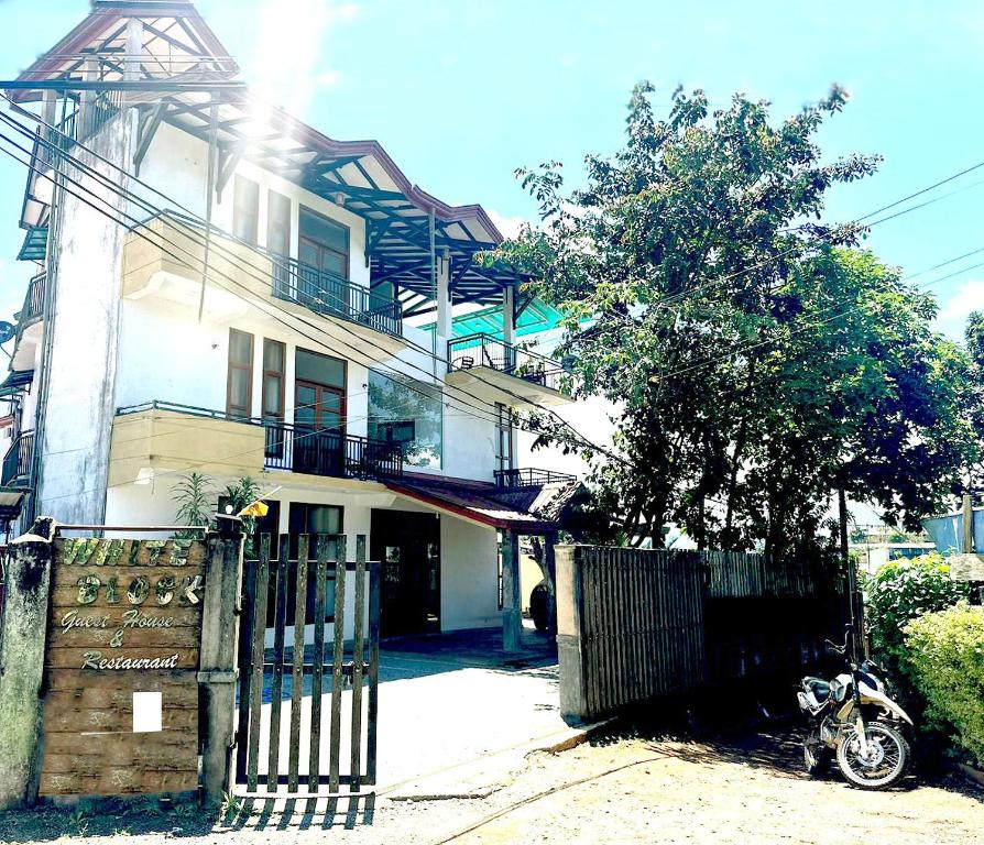 una casa con una motocicleta estacionada frente a ella en White Block Hotel & Resturant en Hatton