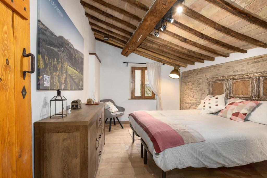 een slaapkamer met een bed en een houten plafond bij Casa Vesta in San Gimignano