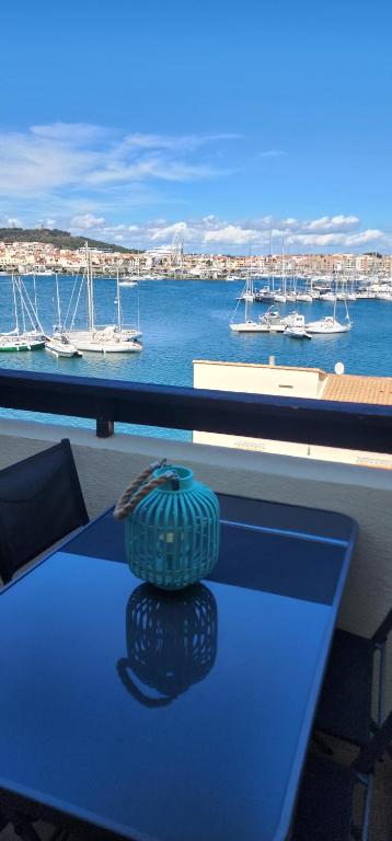 une table bleue avec un vase assis au-dessus dans l'établissement Studio meublé cap d Agde avec tres belle vue sur le port, au Cap d'Agde