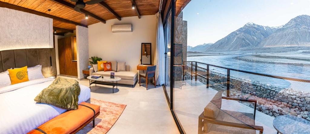 a bedroom with a balcony with a view of the water at Himmel Skardu By Luxus in Skardu