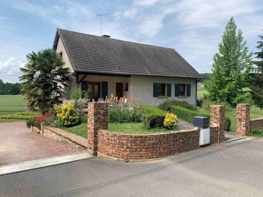 a small house with a brick fence in front of it at Maison de campagne proche de Sézanne avec parking in Le Meix-Saint-Époing