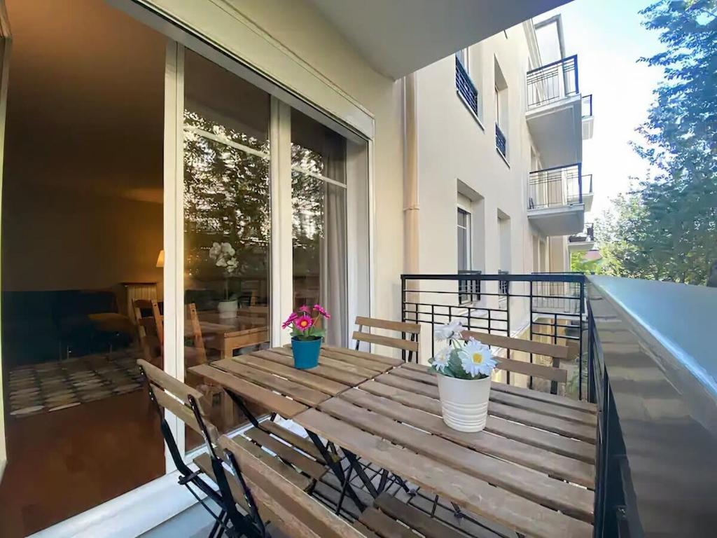 une table en bois sur un balcon avec deux plantes en pot dans l'établissement S10 Disney Shopping Center, à Serris