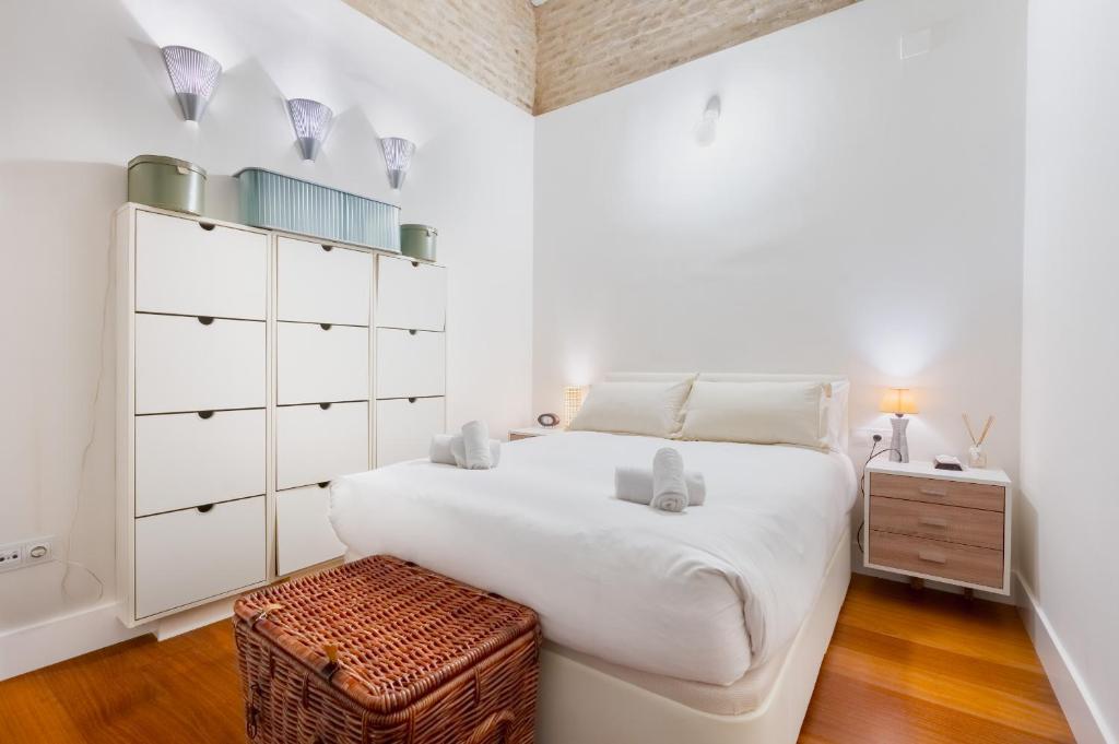 1 dormitorio blanco con 1 cama grande y suelo de madera en Plaza San Marcos Apartment, en Sevilla