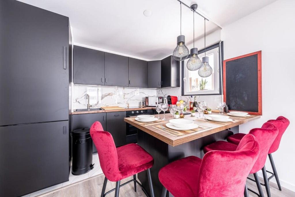 een keuken met rode stoelen en een houten tafel bij Disney Skyline Suite in Bussy-Saint-Georges