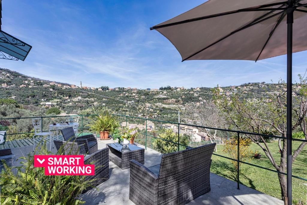 a balcony with an umbrella and a view of a city at Villa Rica by Wonderful Italy in Santa Margherita Ligure