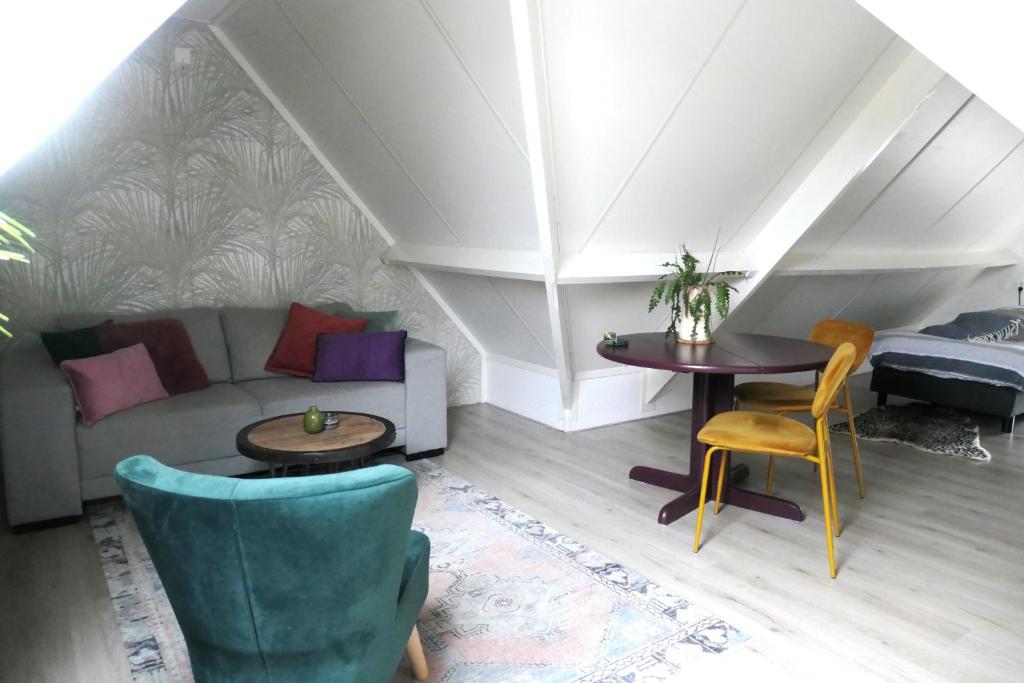 - un salon avec un canapé et une table dans l'établissement Suuthwalda Overnight Stay, à Zuidwolde